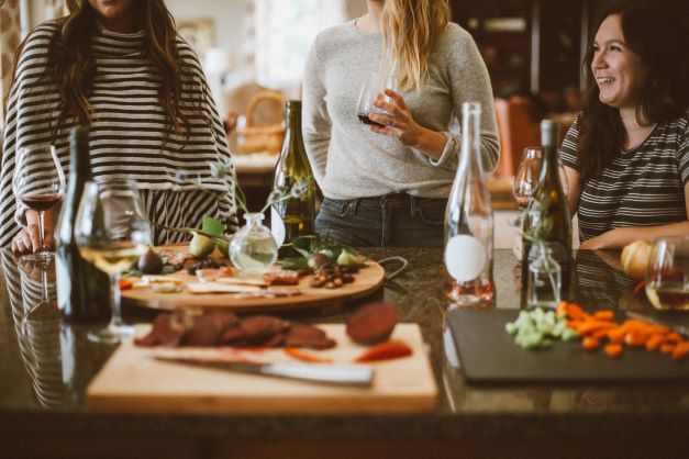 Holiday table with charcuterie board and wine and women in background.