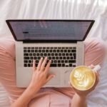 marketer sitting on bed with computer 